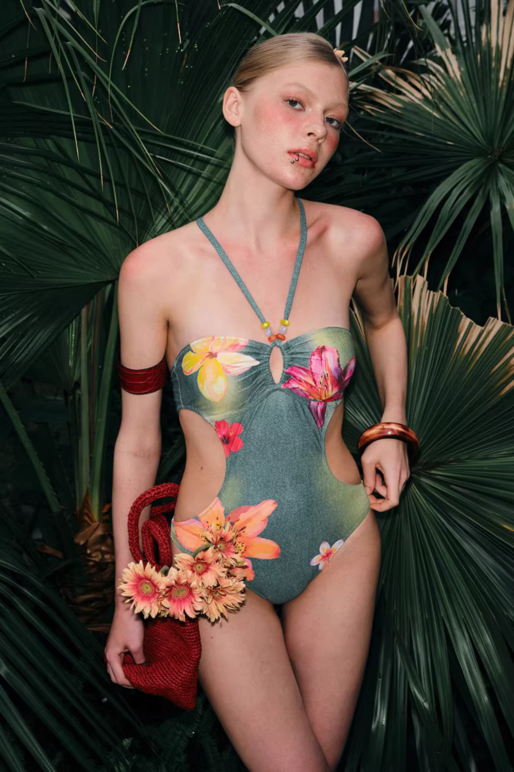 Woman wearing a floral swimsuit surrounded by tropical plants