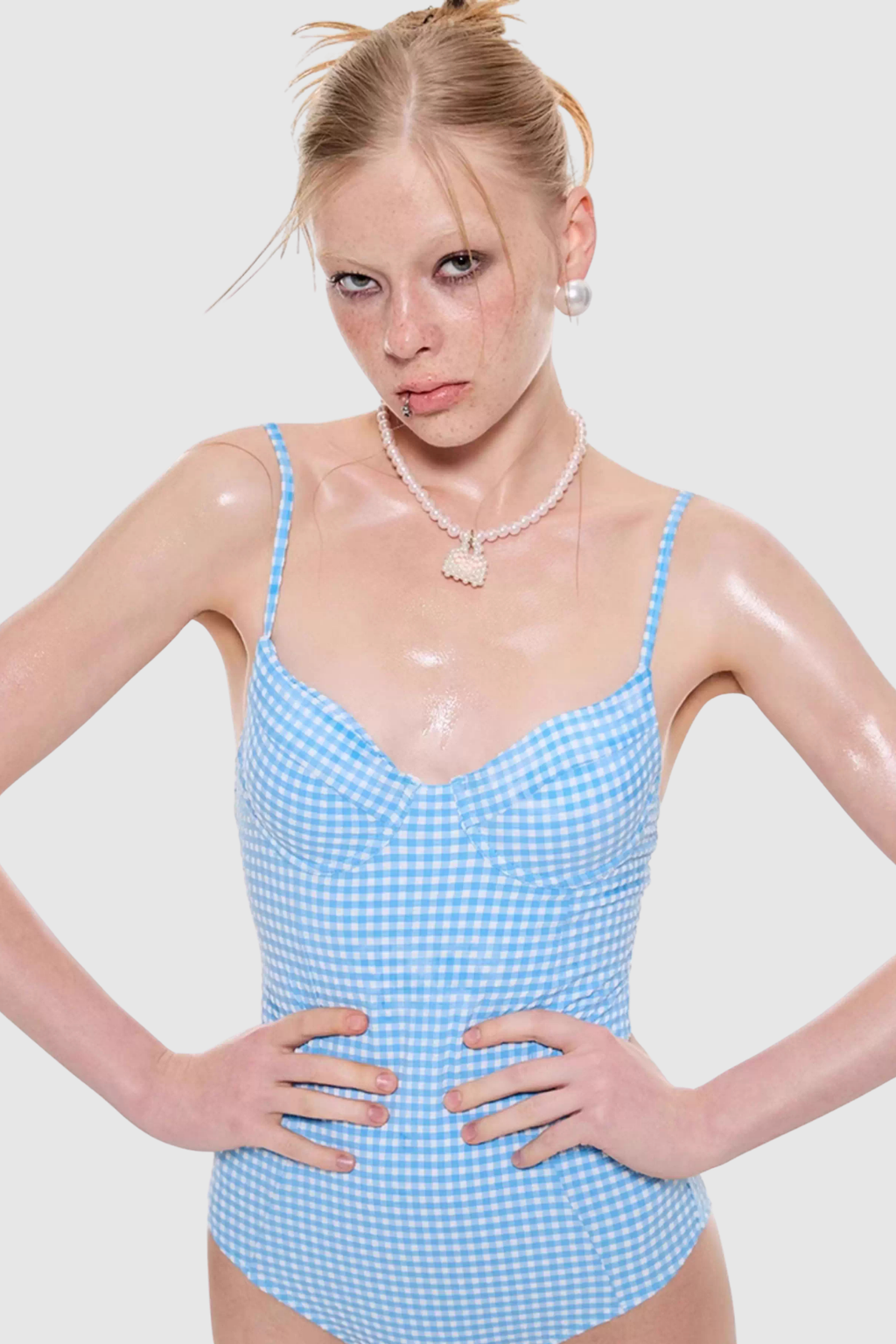 Woman wearing a blue checkered swimsuit against a white background