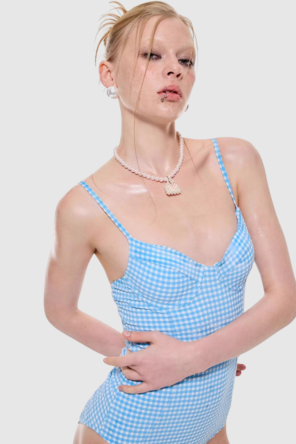 Woman wearing a blue gingham dress with a plain background