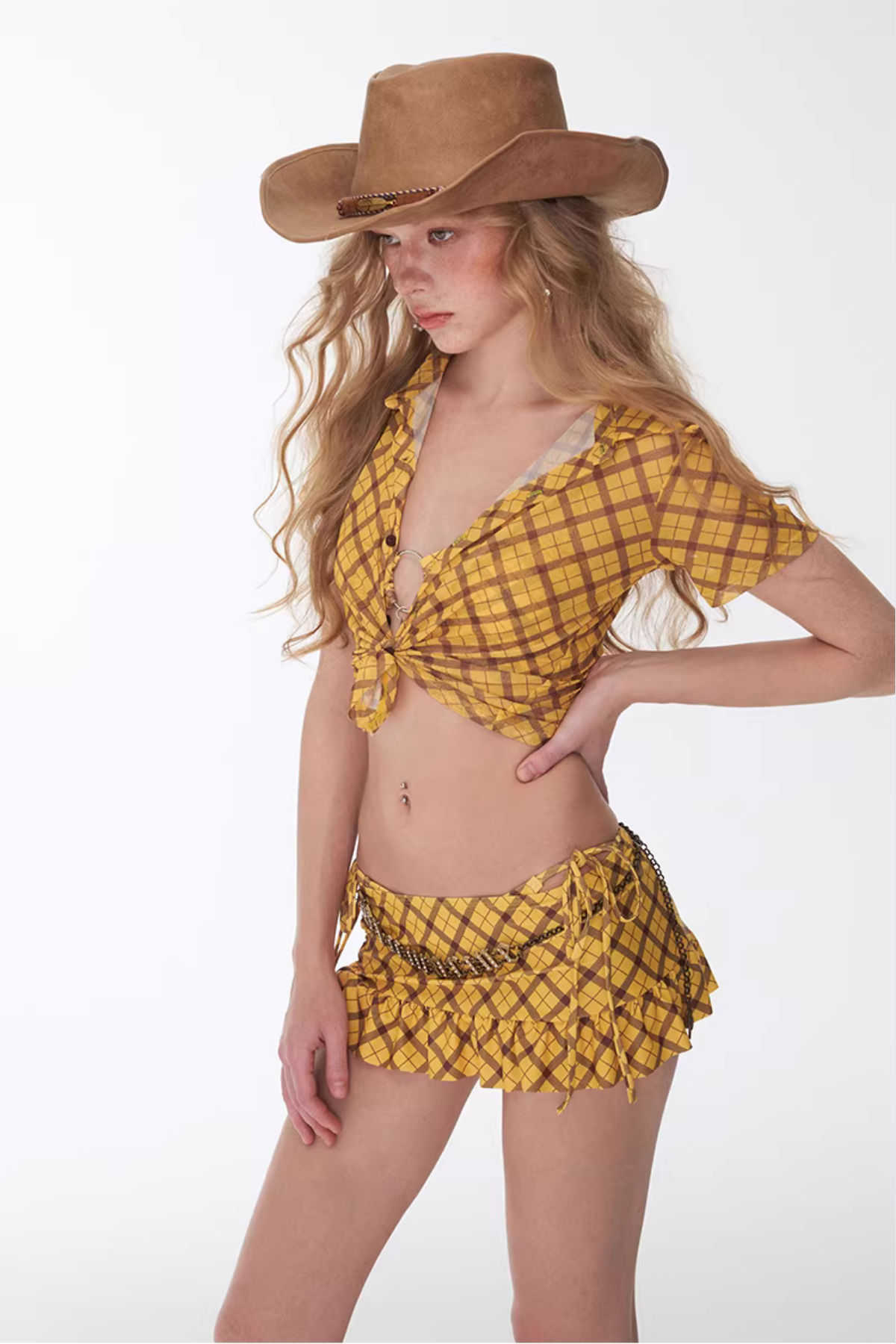 Woman wearing a yellow plaid outfit with a cowboy hat on a white background