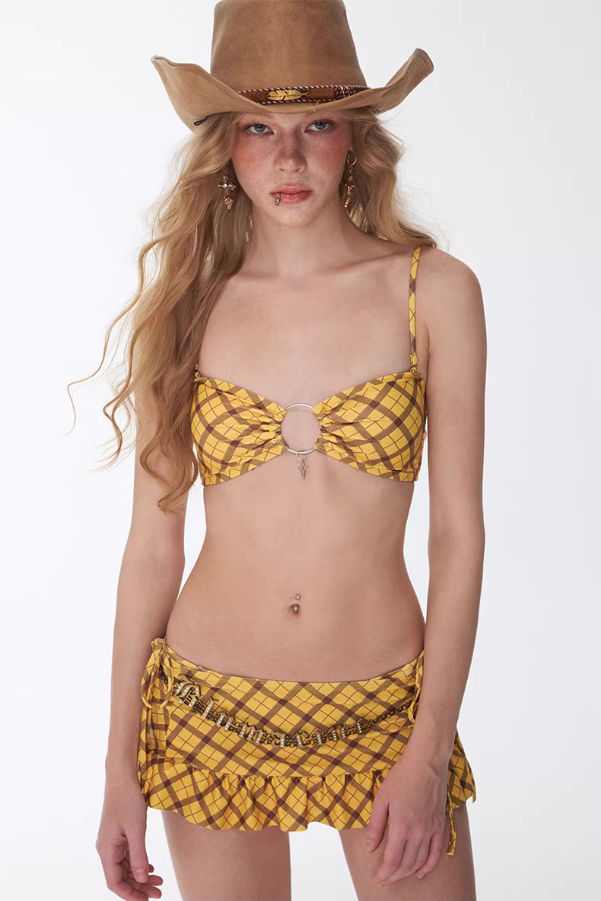 Woman wearing a yellow bikini and cowboy hat on a white background