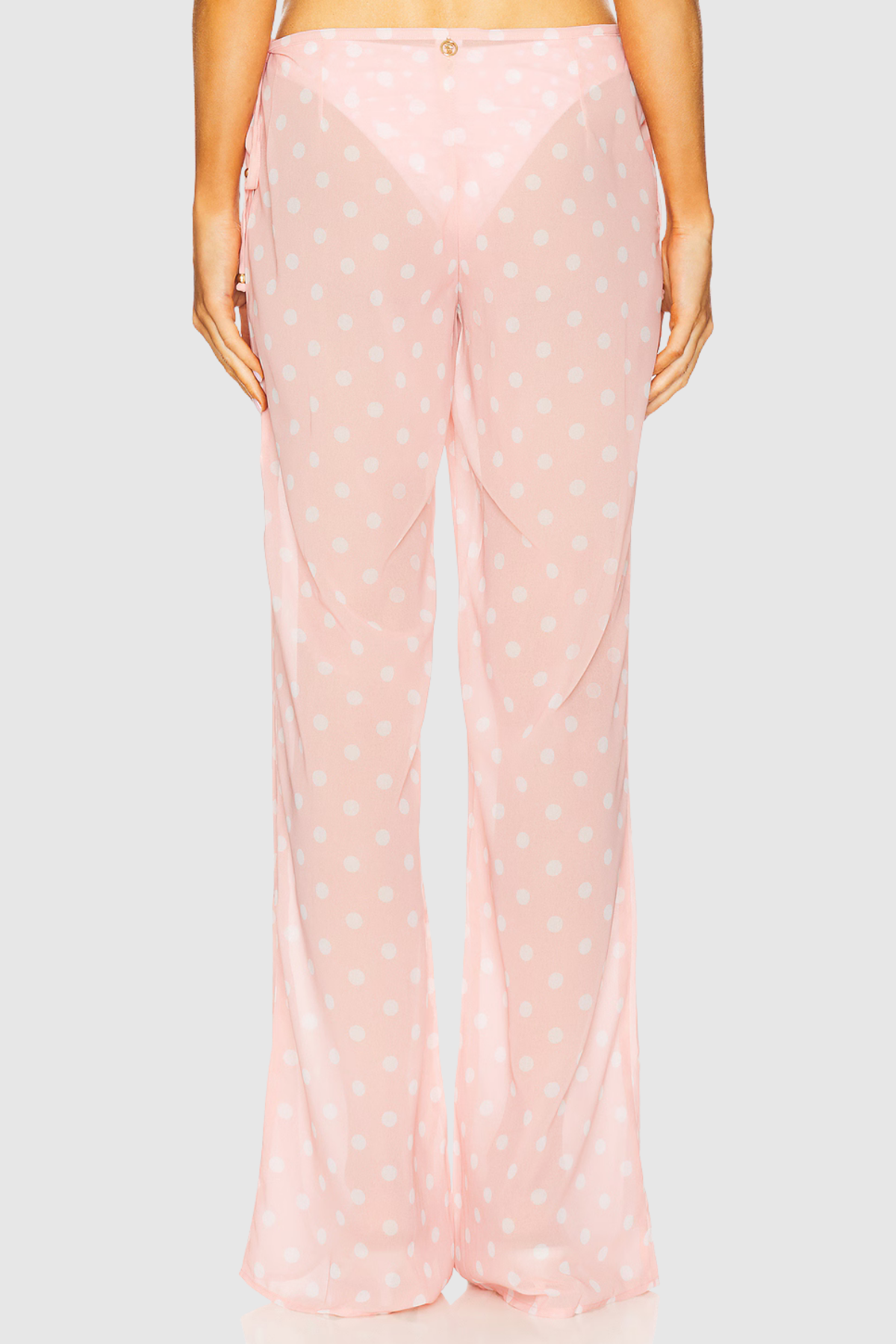Pink polka dot pants on a light gray background